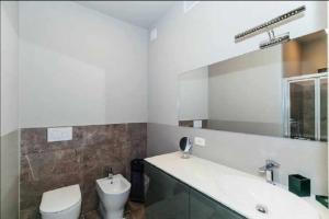 Un baño con lavabo, inodoro y espejo. en Mare a prima vista, en Cervo 10 fotos más
