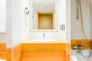 a bathroom with a sink and a mirror at Villa Beaumarchais in Paris