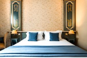 una camera con un letto con due cuscini blu di Villa Beaumarchais a Parigi