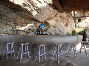a bar with stools in front of a rock wall at Eco del Mare in Lerici