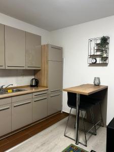 a kitchen with white cabinets and a wooden table at Kod Dide - entry with pin 0-24h in Slavonski Brod