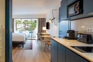 - une chambre d'hôtel avec une cuisine et un lit dans l'établissement Staybridge Suites - Cannes Centre, an IHG Hotel, à Cannes