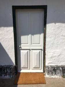 una puerta blanca en el lateral de un edificio en Les Bleuets, en Rue
