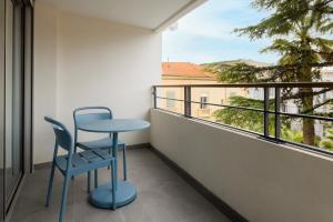 a blue chair and a table on a balcony at Staybridge Suites - Cannes Centre, an IHG Hotel in Cannes