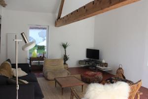 a living room with a couch and a tv at Les Bleuets in Rue
