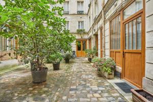 alejka z doniczkami i budynek w obiekcie Apartment Montmartre by Studio prestige w Paryżu