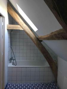 a bathroom with a bath tub in a attic at Les Bleuets in Rue