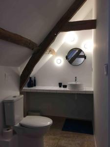 a bathroom with a white toilet and a sink at Les Bleuets in Rue