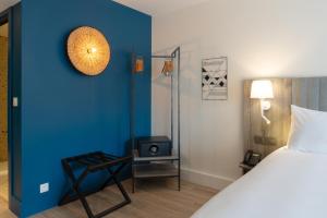 1 dormitorio con cama y pared azul en Staybridge Suites - Cannes Centre, an IHG Hotel en Cannes