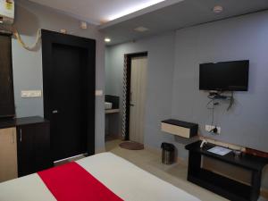 a bedroom with a bed and a tv on the wall at SSJ Premium in Bhubaneshwar