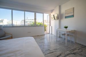 Schlafzimmer mit einem Bett, einem Tisch und einem Fenster in der Unterkunft Hostal Antiguo Palacio Hotel París in Huelva