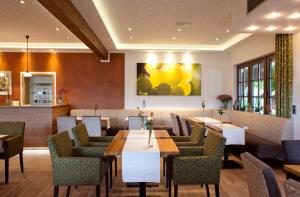 a restaurant with tables and chairs and a painting on the wall at Weinhotel Sonnenschein in Ernst