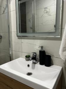 a white sink in a bathroom with a mirror at Kod Dide - entry with pin 0-24h in Slavonski Brod