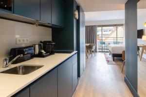 Il comprend une cuisine avec un évier et une chambre avec un lit. dans l'établissement Staybridge Suites - Cannes Centre, an IHG Hotel, à Cannes