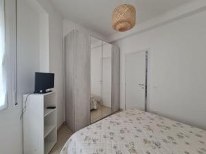 Habitación blanca con cama y TV en Sant'Agostino 2, en San Remo