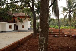 a house with a tree in front of a yard at Best Heritage Home in Iritti