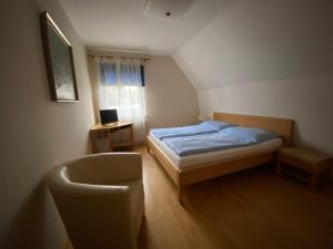 a small bedroom with a bed and a chair at Haus Clearwater in Bruck an der Mur