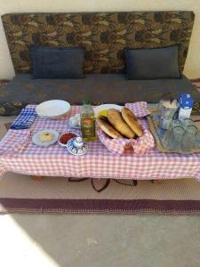 a picnic table with a plate of food on a bed at DAR BRAHIM 