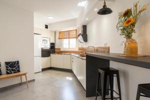 una cucina con armadi bianchi e piano di lavoro nero di VILLA WINE & BEACH Design and Luxury in Cala Crancs a Salou