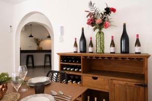una sala da pranzo con tavolo e bottiglie di vino di VILLA WINE & BEACH Design and Luxury in Cala Crancs a Salou