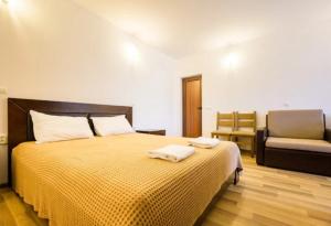 een slaapkamer met een bed met twee handdoeken erop bij Къща за гости и спорт Анелия in Vŭrben