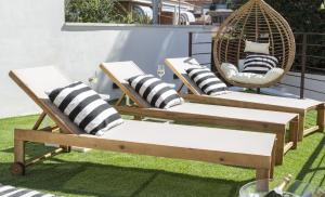 2 sedie e un'altalena su un patio di VILLA WINE & BEACH Design and Luxury in Cala Crancs a Salou