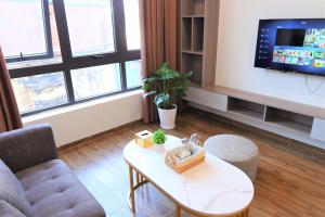 - un salon avec un canapé, une table et une télévision dans l'établissement Funhome Apartment Giang Vo Ha Noi, à Hanoï