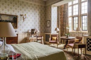 a bedroom with a bed and a table and chairs at Hartwell House & Spa in Aylesbury