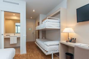 Habitación de hotel con litera y baño en Hotel Lauria en Tarragona