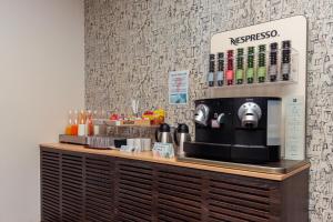 a coffee shop with a coffee machine on a counter at Hotel Lauria in Tarragona