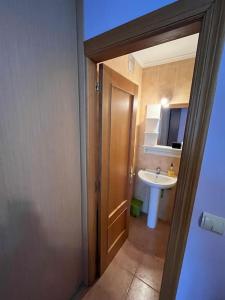 a bathroom with a sink and a toilet and a door at Mies de Estrada in Comillas