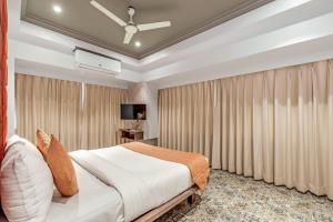 a bedroom with a large bed and curtains at Emerald Retreat in Lonavala