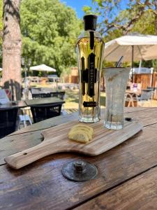 - une bouteille de vin sur une planche de découpe en bois avec un verre dans l'établissement Camping du Pont d'Avignon, à Avignon