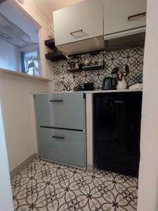 een keuken met een koelkast en een tegelvloer bij La casa nel borgo in Parma