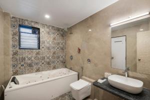 a bathroom with a tub and a toilet and a sink at Emerald Retreat in Lonavala