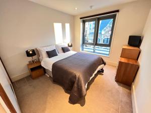 a bedroom with a bed and a large window at Deluxe Central Entire Flat at Farringdon Station London in London