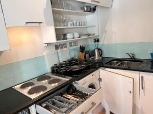 a small kitchen with a stove and a sink at Deluxe Central Entire Flat at Farringdon Station London in London