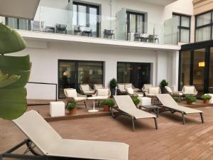 a hotel lobby with chairs and tables and windows at Hotel Lauria in Tarragona