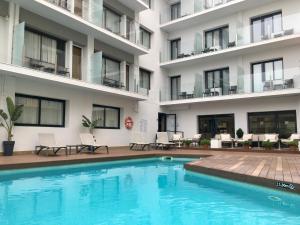 a swimming pool in front of a building at Hotel Lauria in Tarragona