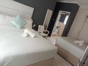 1 dormitorio con cama blanca y espejo en BARAKA mtata ! en Mthatha