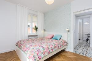 1 dormitorio con 1 cama con colcha de flores en Baker Street, en Varsovia