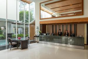 two people sitting at a reception desk in a lobby at Kantary Hills Hotel, Chiang Mai in Chiang Mai