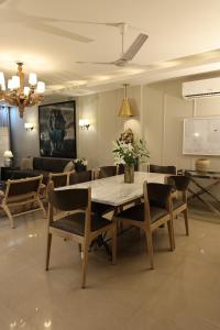 a dining table and chairs in a living room at R6 Luxury Peacefull & Comfortable in New Delhi