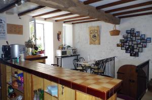 a kitchen with a counter and a table in a room at Maison d'Hôtes Le Cadran Solaire in Courcelles