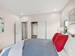 a bedroom with white walls and a bed with red pillows at Newly Constructed Priv. Entry Master Suite in San Jose