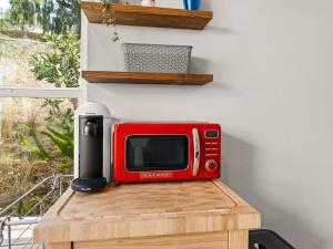 a red microwave sitting on top of a wooden table at Newly Constructed Priv. Entry Master Suite in San Jose