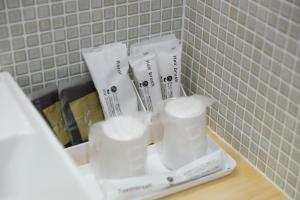 - un comptoir de salle de bains avec des serviettes blanches et des brosses à dents dans l'établissement みつくりHOTEL, à Tuyama