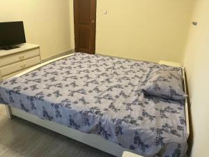 Schlafzimmer mit einem Bett mit einer blauen und weißen Bettdecke in der Unterkunft Residence ABIS 