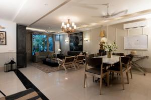 a dining room and living room with a table and chairs at R6 Blissful Bangalow in New Delhi