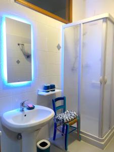 La salle de bains est pourvue d'un lavabo, d'une douche et d'une chaise. dans l'établissement Casa Italia - Appartamento con giardino e cortile privato, à Sinalunga